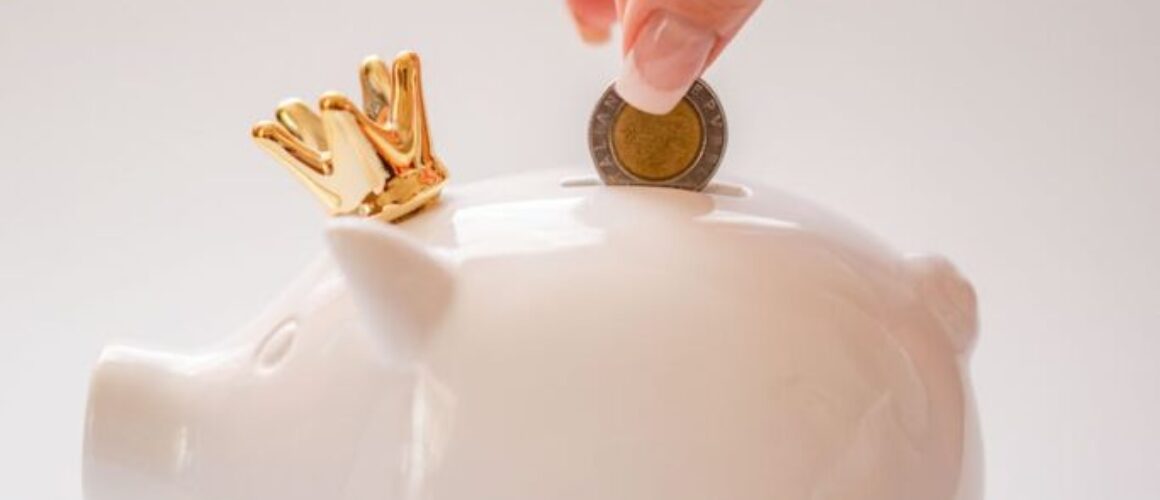 hand putting coins into a piggy bank